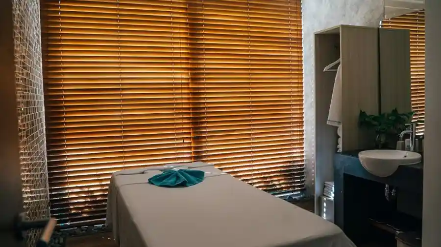 Quiet treatment room interior with a bed and wooden window blinds