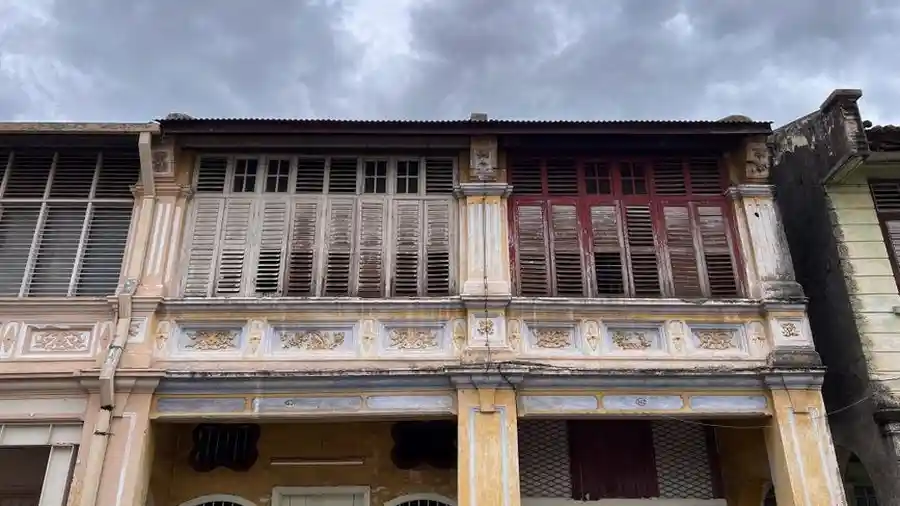 Row of weathered heritage shophouses on a George Town street