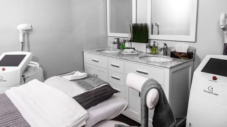 Empty treatment room with a laser device, trolley and folded towels