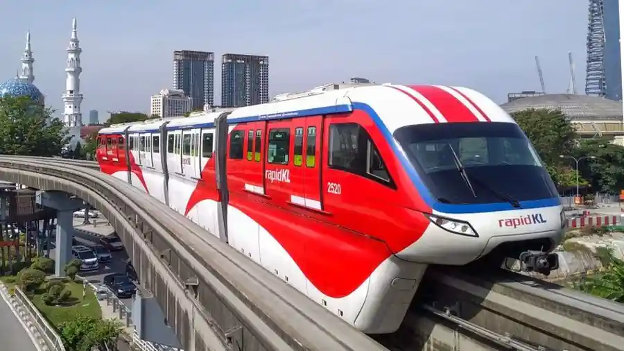 Elevated monorail train passing through a Kuala Lumpur city district