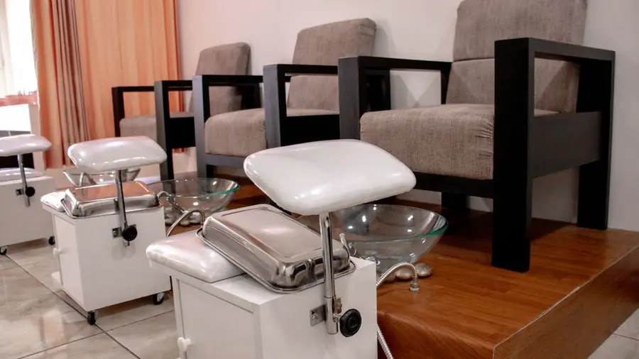 Empty pedicure chairs and footbaths in a quiet nail salon