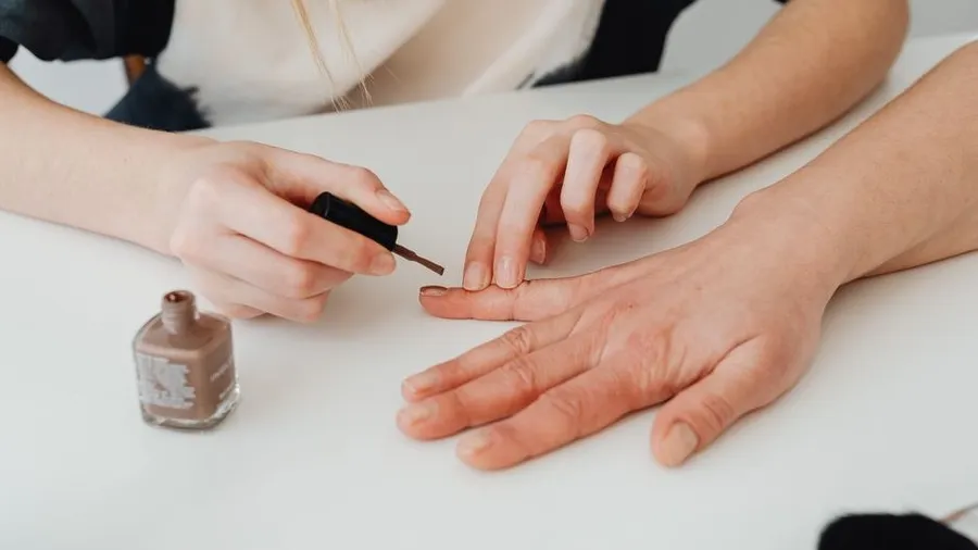 Close-up of hands during a manicure with nail polish application