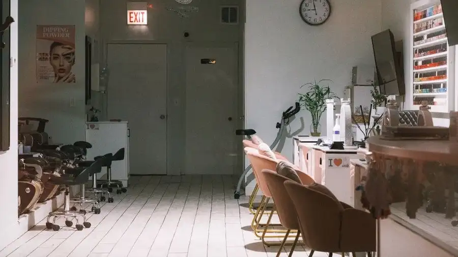 Modern nail salon interior with waiting chairs and reception desk