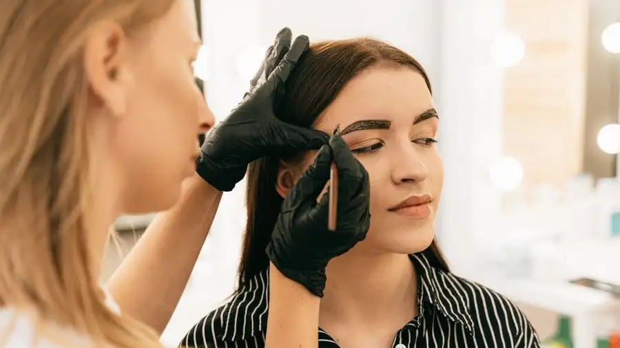 Close view of eyebrow shaping being performed at a beauty salon