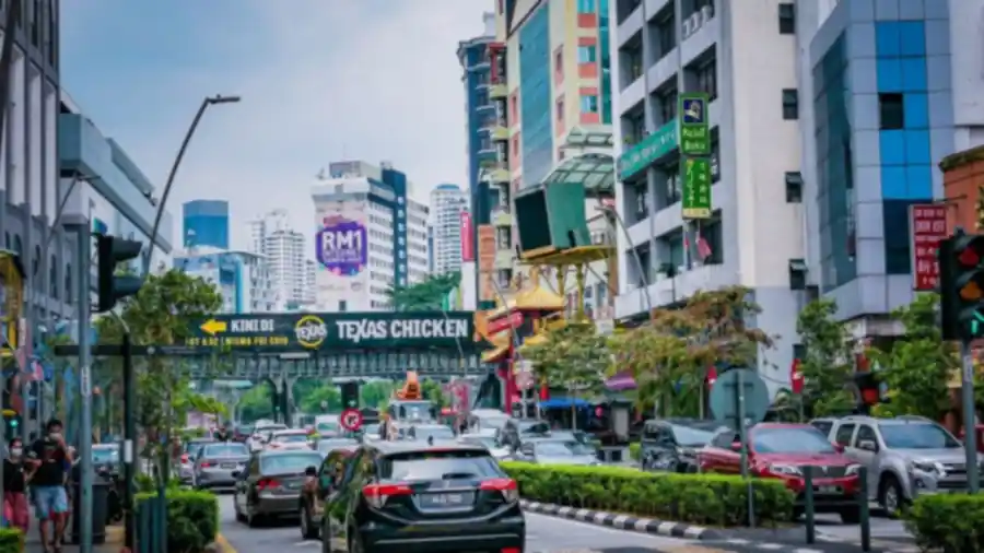 Busy Kuala Lumpur city street with shops and traffic