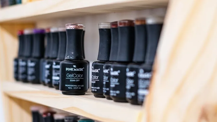 Shelf of gel nail polish bottles in a salon