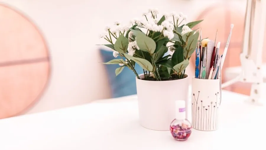 Bright nail salon desk with brushes and a small plant