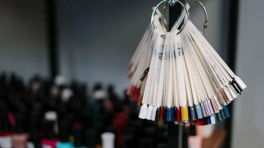 Colour swatch ring of nail polish shades held up in a salon