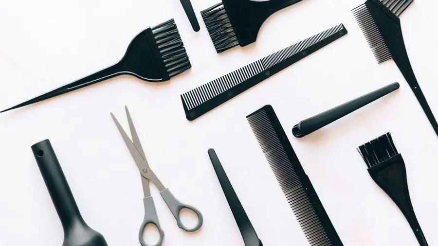 Flat lay of combs, scissors and brushes on a hairdresser's table