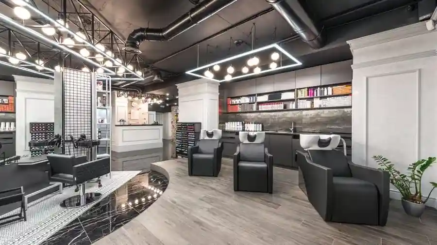 Bright modern hair salon interior with styling chairs and a wall of colour products