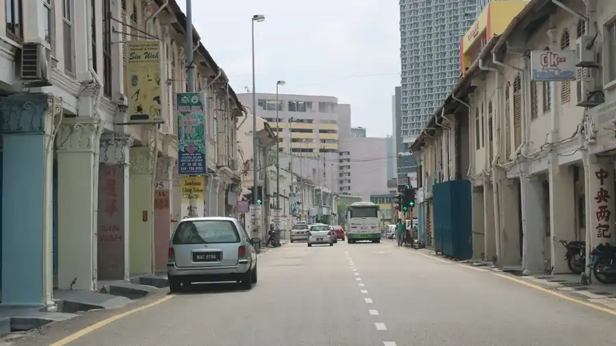 Row of shophouse units along a quiet Malaysian street with parked cars