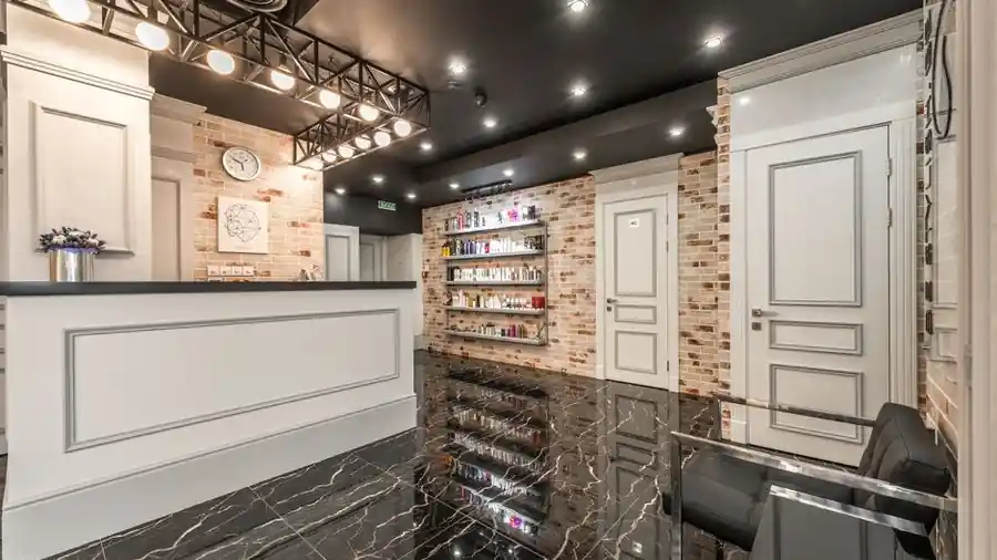 Bright beauty salon reception counter with a vase of flowers and product shelves