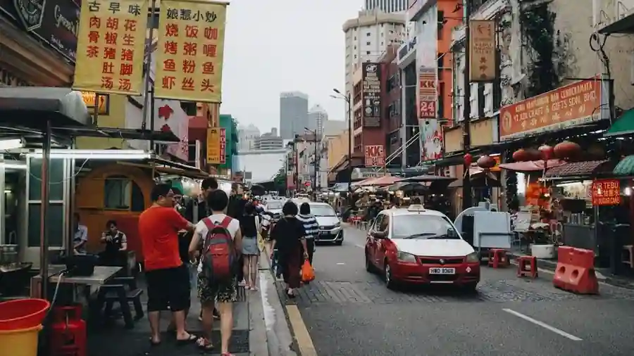 Busy Kuala Lumpur street lined with shop lots and signage