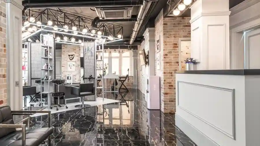 Interior of a beauty salon with mirrored stations and a reception counter