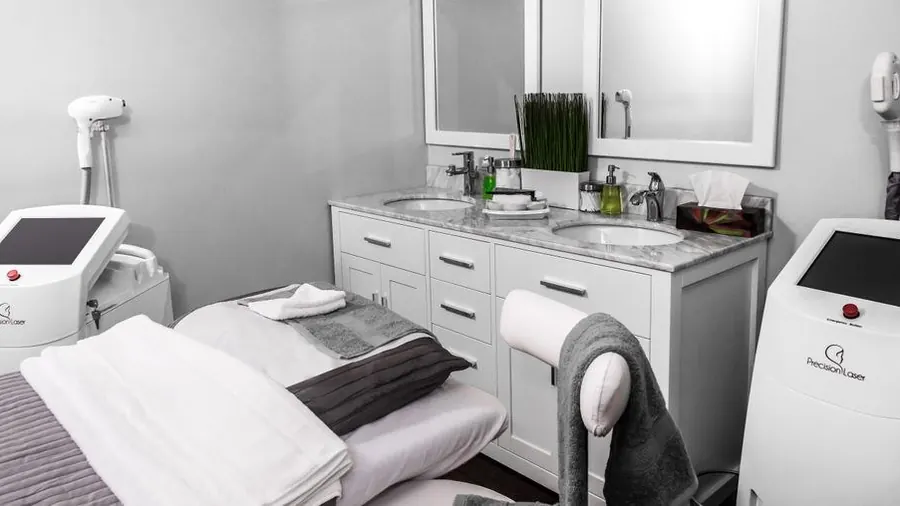 Clean modern aesthetic clinic treatment room with device and chair