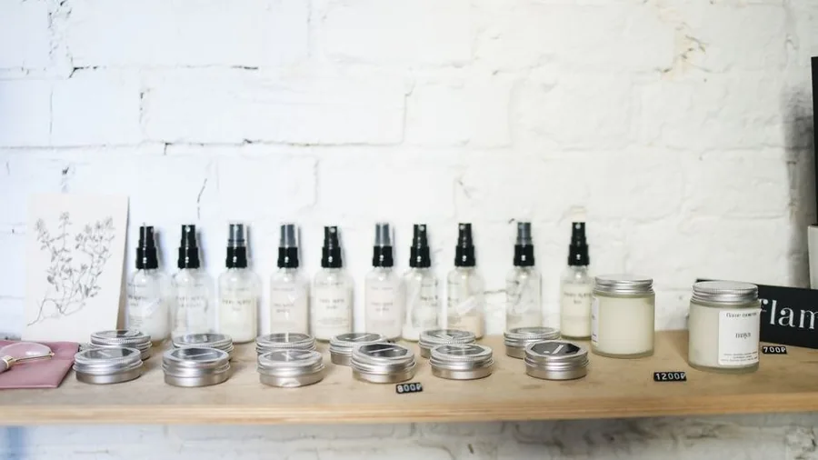 Shelf of small skincare bottles and tins in a bright shop