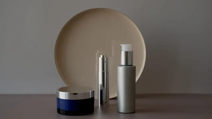 Skincare jar and bottles arranged on a neutral shelf