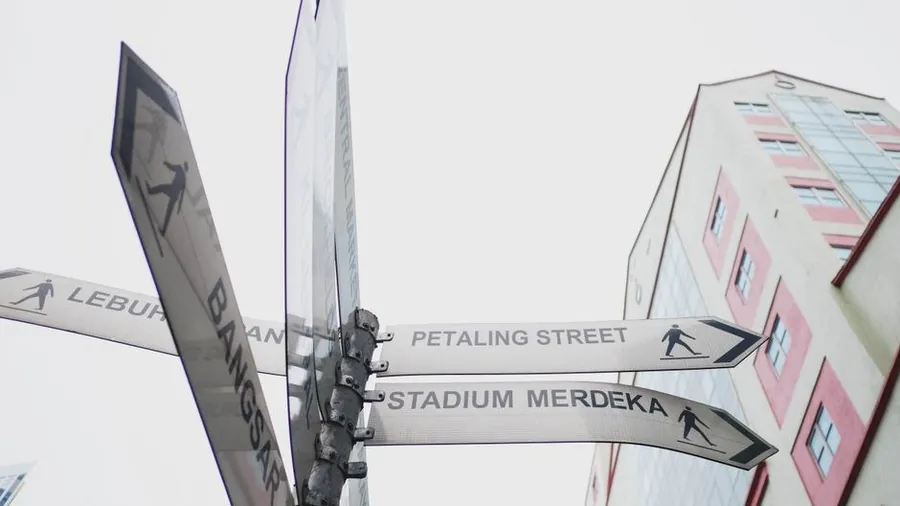 Street signs pointing to Petaling Street and Stadium Merdeka in Kuala Lumpur