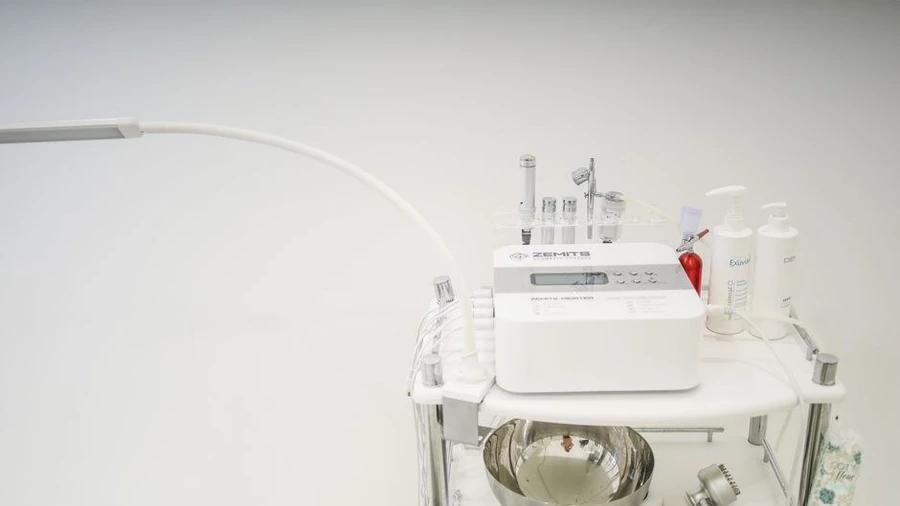 Skincare device with tubing and bottles standing in a clinic treatment room