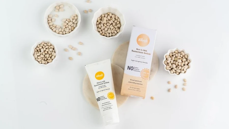 Sun protection lotion and skincare products arranged on a pale surface