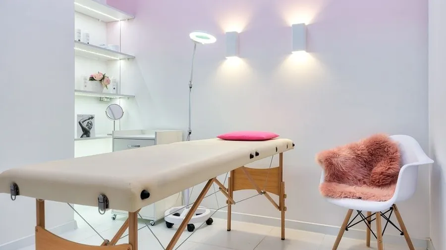 Empty treatment room with a couch and skincare shelving
