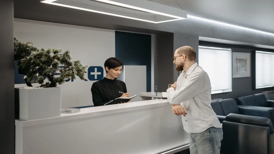 Reception desk at a modern aesthetic clinic with a consultation in progress