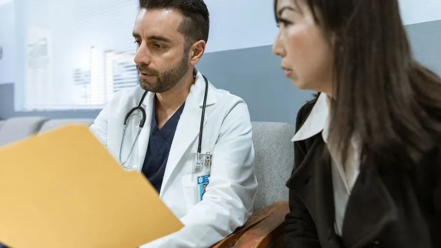 Doctor reviewing patient file during a clinic consultation