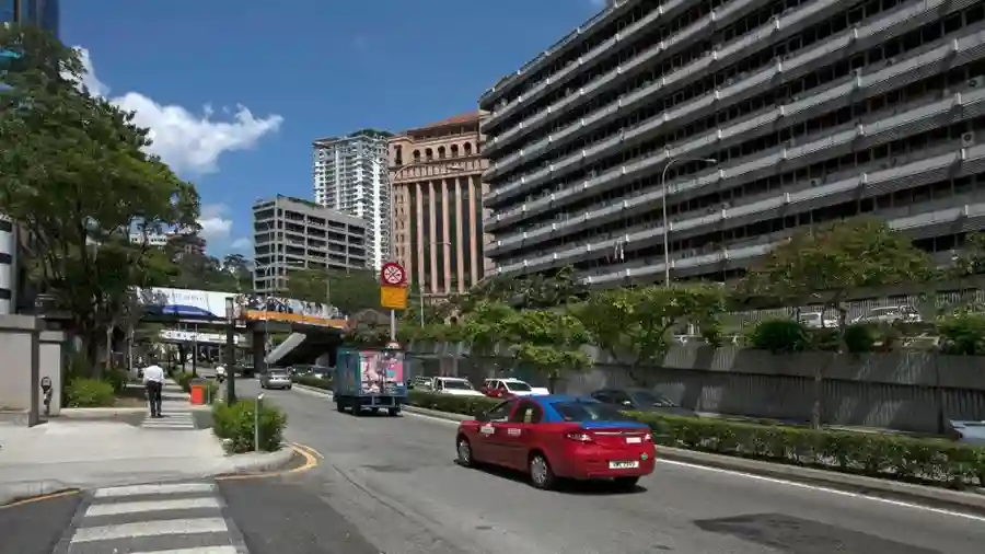 Busy city street in Kuala Lumpur with traffic and modern buildings