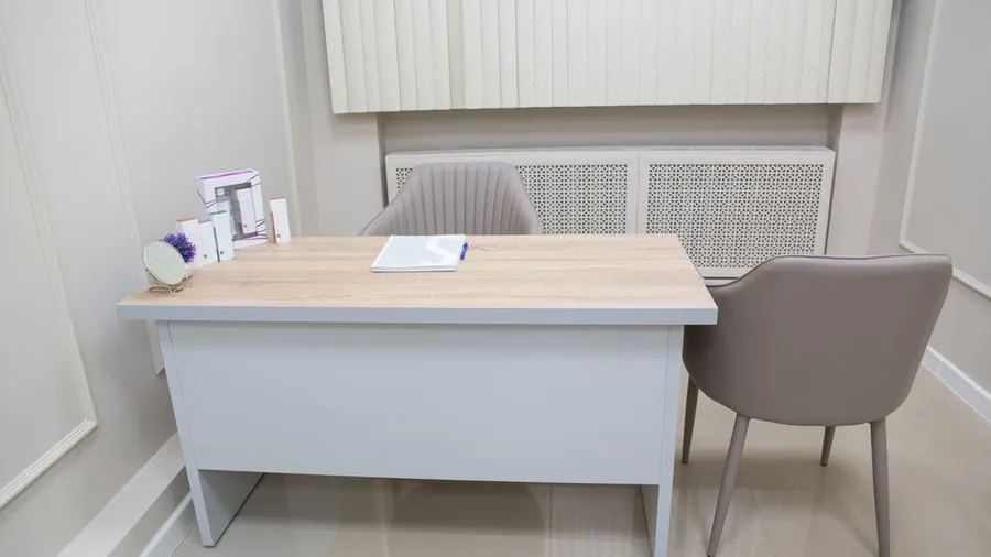 Consultation room with a desk and skincare products at a private aesthetic clinic