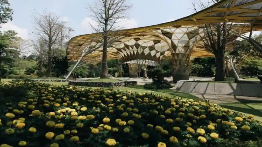 Landscaped public garden with flower beds and a canopy structure
