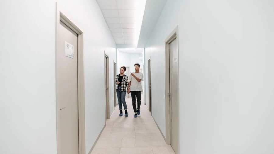 Two people walking along a bright corridor in a modern medical centre