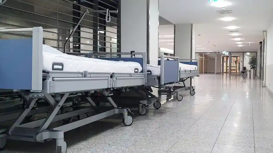 Quiet hospital ward with empty beds in a bright corridor