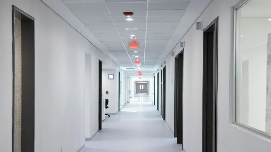 Bright empty hospital corridor with white walls and even lighting