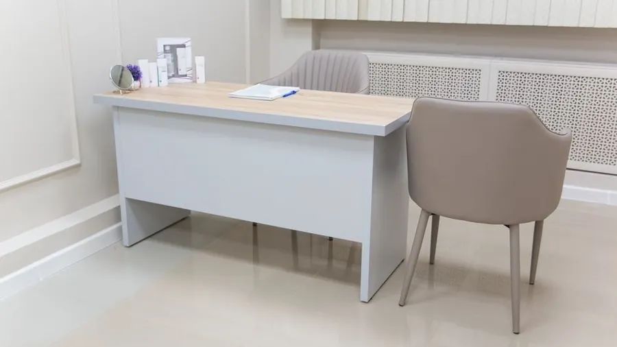 Quiet private consultation room with a plain desk and two chairs