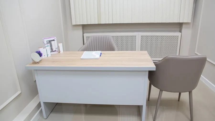 Plain consultation desk with two chairs in a quiet clinic room