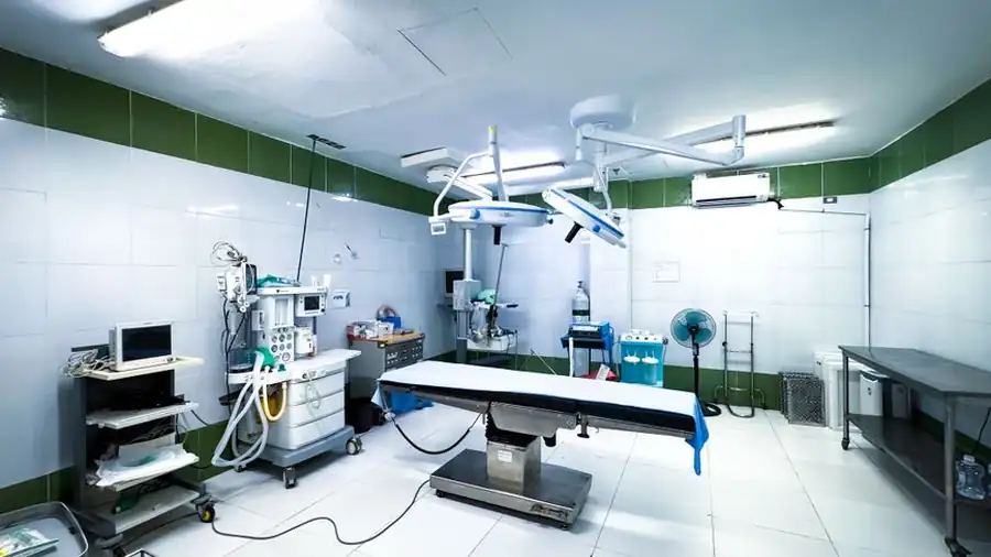 Empty operating theatre with a surgical table and overhead lights