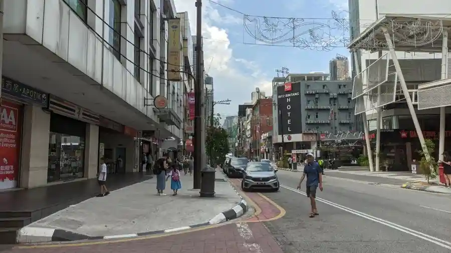 Modern city street with shopfronts and pedestrians in Kuala Lumpur
