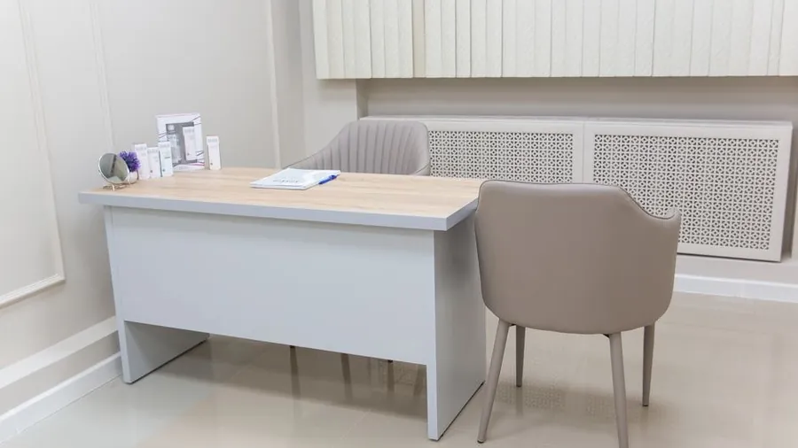 Minimalist clinic consultation desk with two empty chairs