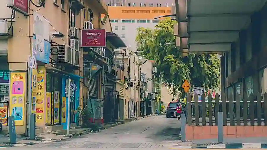 Quiet shoplot street with cafes and clinic signage in a Kuala Lumpur suburb