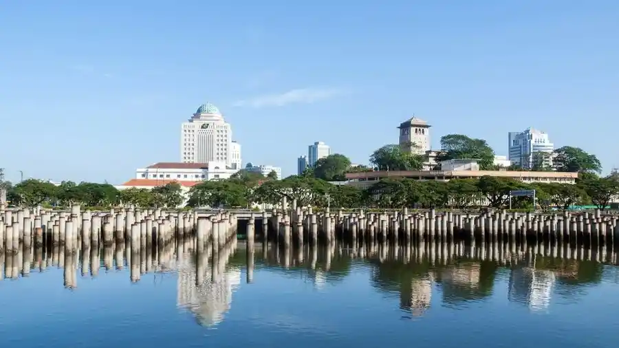 Johor Bahru waterfront skyline with a domed heritage building and reflection