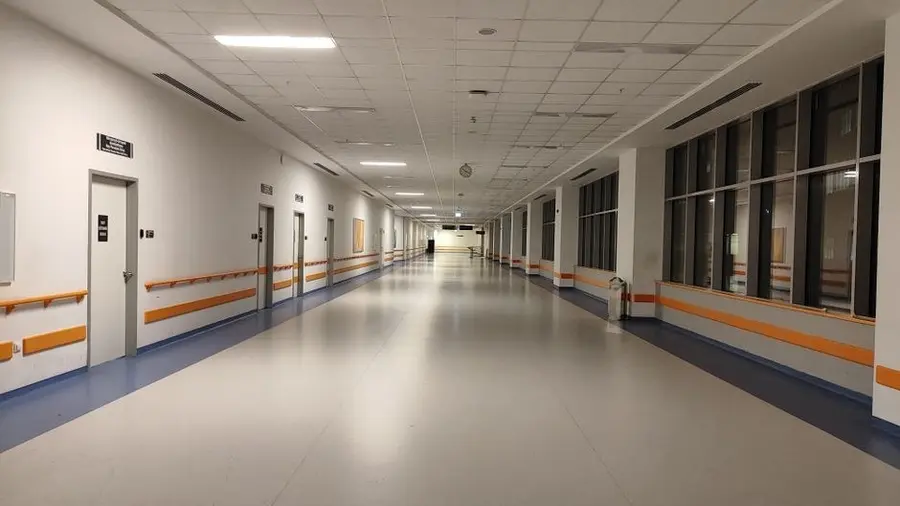 Empty modern clinic corridor with clean flooring and doorways