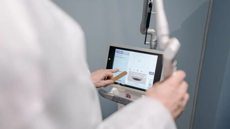 Clinician operating a touchscreen on a laser device