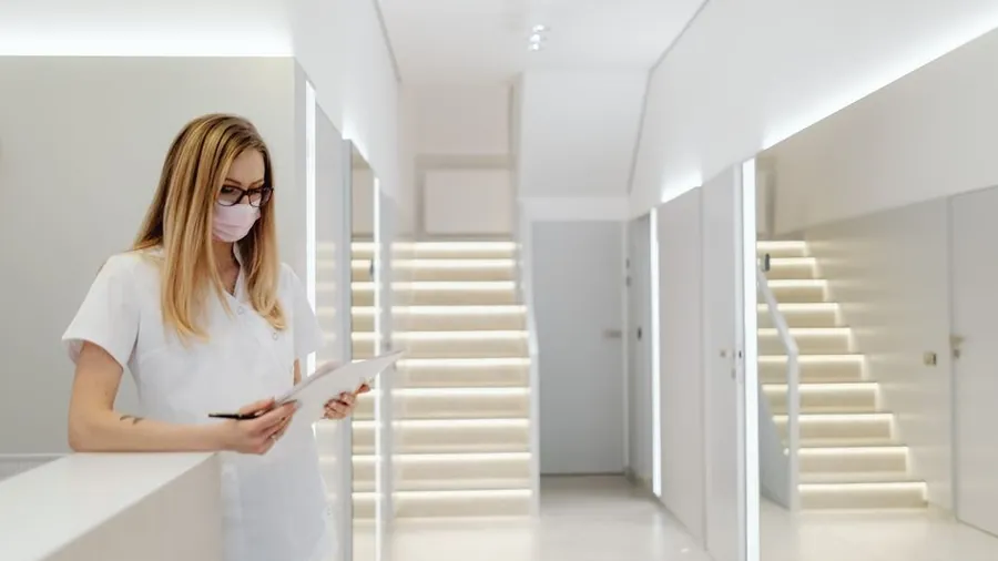 Clinician in a bright clinic corridor with soft lighting