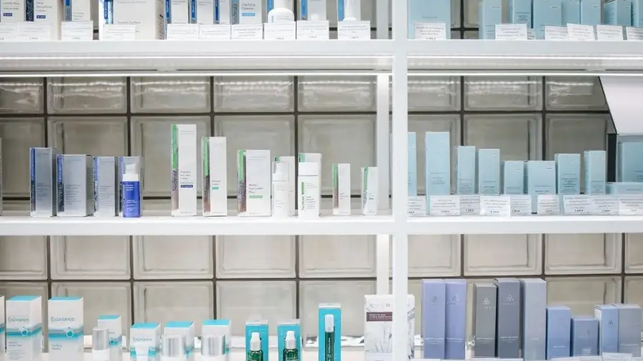 Rows of skincare products on white retail shelves