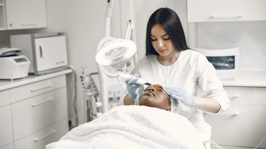 Practitioner performing a facial treatment at a clinic