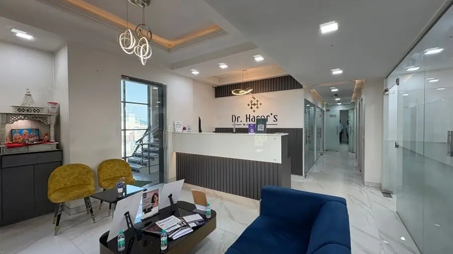 Aesthetic clinic reception area with pale seating and a lit counter