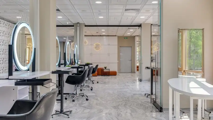 Contemporary hair and beauty salon interior with lit mirrors and styling chairs